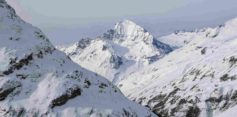 Sommet enneigé entouré de montagnes blanches dans le massif de la Vanoise, sous un ciel d'hiver.